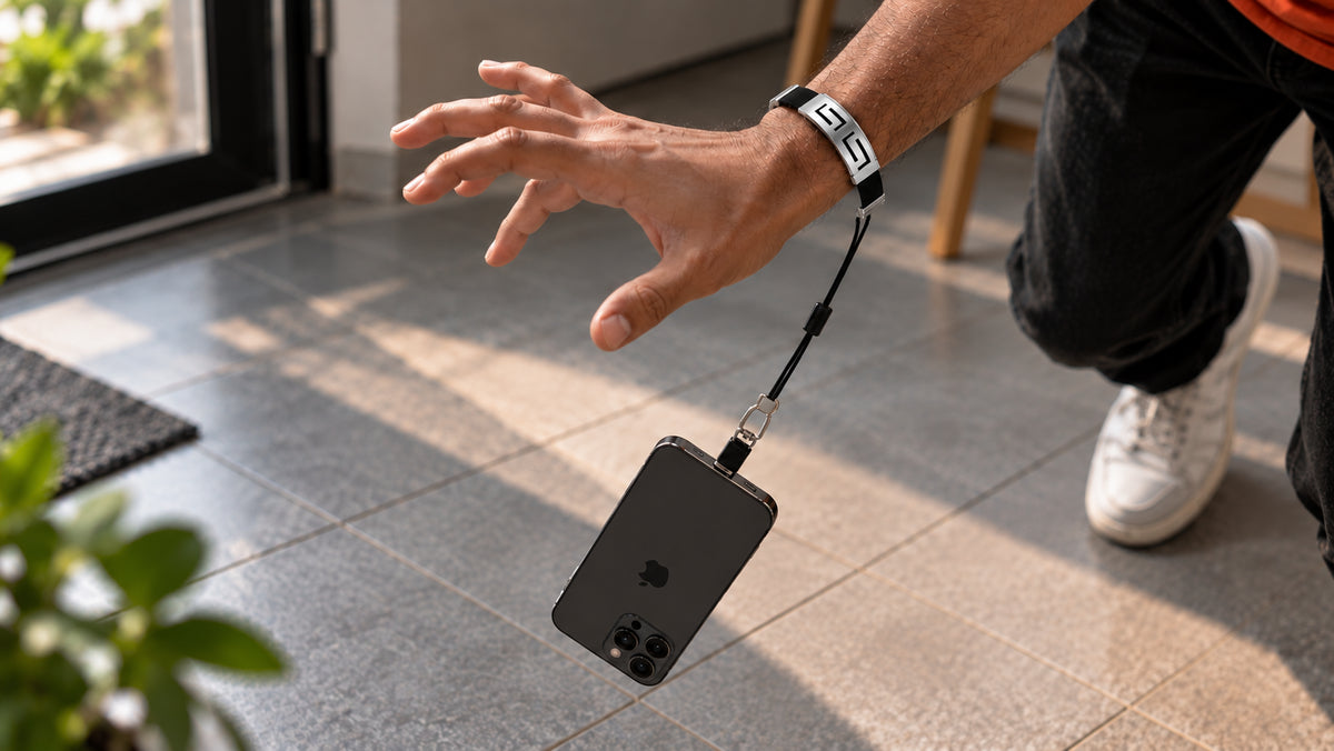 Phone left hanging safely from a wrist tether after slipping out of the user's hand