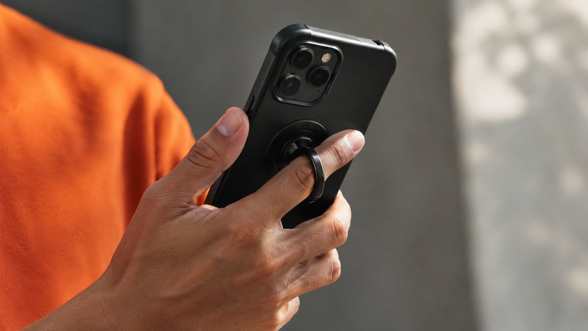 Finger grip strap on the back of a phone held between two fingers